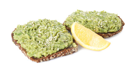 Delicious sandwiches with avocado cream, sesame seeds and lemon wedge isolated on white
