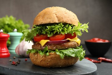 Delicious hamburger with patty served on black table, closeup