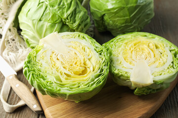 Fresh cabbages, net bag and knife on wooden table, closeup © New Africa