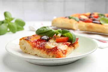 Piece of tasty homemade pizza on white wooden table, closeup