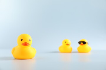 Three cute rubber ducks on white background