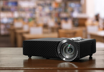 Modern video projector on white table in public library