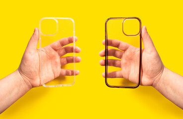 Hands holding two transparent phone cases, one clean and one dirty against bright yellow backdrop....