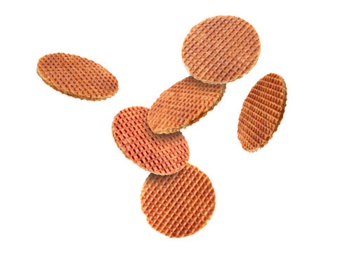 Yummy Dutch waffles (stroopwafels) flying on white background