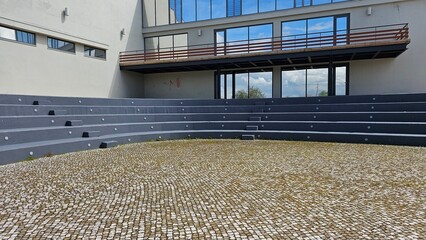 Outdoor Amphitheater With Concrete Benches and Modern Building Facade