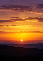 Obraz premium Golden sunset over mountain range landscape with colorful cloudscape