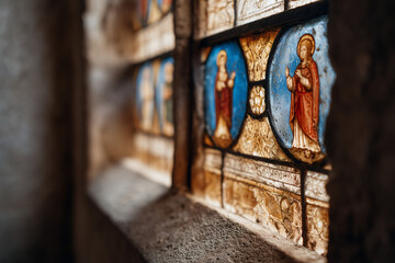 A close-up of a stunning stained glass window featuring vibrant religious imagery, bathed in natural light