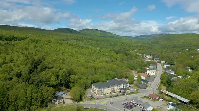 Aerial View of Small Mountain Town with River and Bridge in Maine, drone 4K