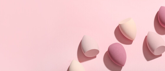 Many makeup sponges on pink background