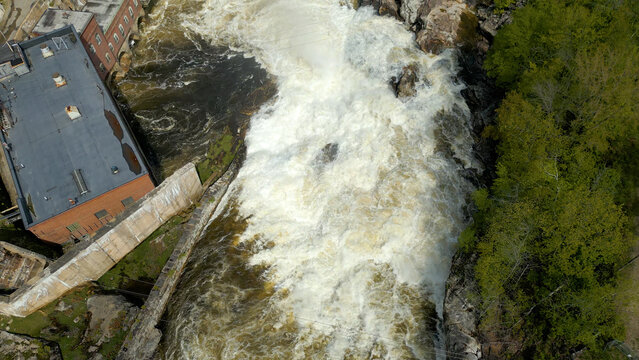 Aerial View of Flowing River with Foam Patterns and Forest Shoreline in Maine