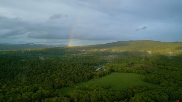 Aerial View of Rainbow Over Forested Mountains in Rural Maine at Sunset