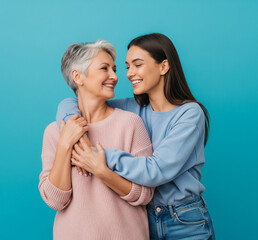 Cheerful fun satisfied elder parent mom with young adult daughter two women together wearing casual clothes hugging cuddle look to each other isolated on plain blue cyan background. Family day concept