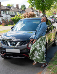 Birmingham England UK.  Happy young African woman  buying a car  in the street.