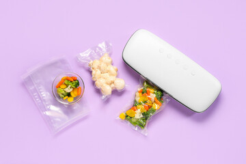 Vacuum sealer machine for food with chopped vegetables and mushrooms in packs on lilac background