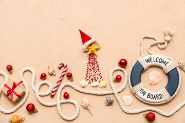 Decor lifebuoy ring, rope, shells and starfish with Christmas decor on beige background. Top view
