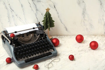 Vintage typewriter with Christmas tree and balls on white background