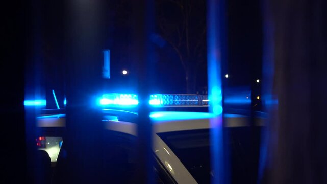 Close-up of blue police lights flashing in the dark. Emergency beacons glow with intense color and reflections, symbolizing law enforcement, urgency, and public safety.

