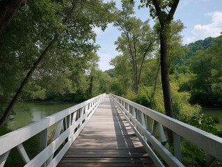 Obraz premium Wooden bridge stretches over a serene river surrounded by lush greenery on a sunny day