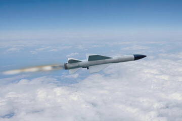 A military Russian rocket flies across a clear blue sky above a layer of white clouds.