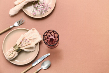 Beautiful table setting with silver cutlery and gypsophila flowers on brown background