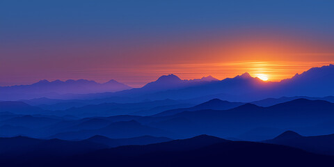 Blue dawn over misty mountain ranges with sunlight
