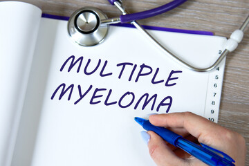 MULTIPLE MYELOMA - words in a notebook against the background of a stethoscope and a doctor's hand with a pen