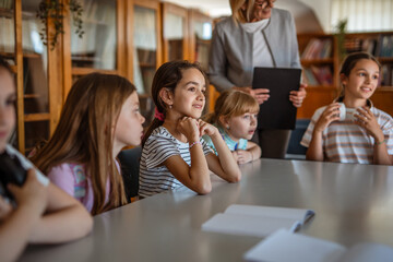 teacher is give the lesson to pupils in the school library