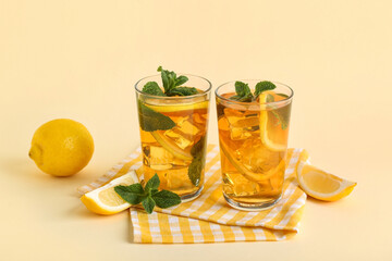 Fototapeta premium Glasses of lemon ice tea with mint on beige background