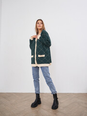 Stylish young woman poses casually in modern interior, showcasing her fashion sense