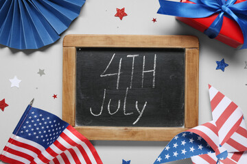 Obraz premium Chalkboard with text 4TH JULY, USA flag and gift box on grey background. Independence Day celebration