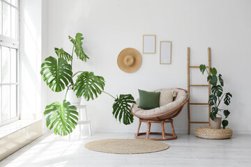 Interior of living room with Monstera plants, armchair and ladder © Pixel-Shot