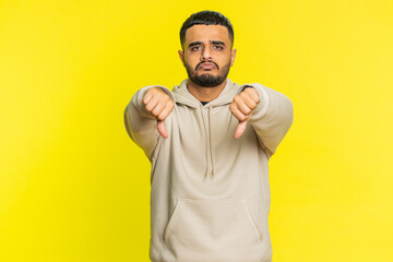 Dislike. Upset unhappy Indian man showing thumbs down sign gesture, expressing discontent,...