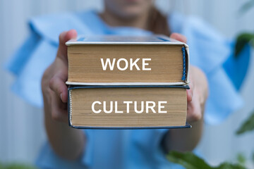 Young girl holding two books with inscription on side: WOKE CULTURE. Woke Culture Social Issues Political Diversity Pepole Rights concept.