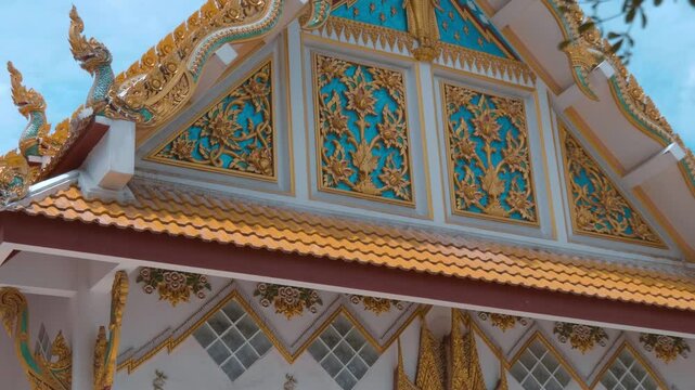 Elaborately decorated with golden elements gable and amazing Ayutthaya-style dragon-like gilded chofahs and elements of the roof of Wat Na Phra Meru in Ayutthaya, Thailand. Shot in motion