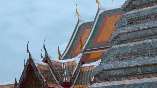 Traditional Thai Buddhist temple with beautiful red, orange and blue tiled roof with magnificent chofas in Thai architectural style. Shot in motion