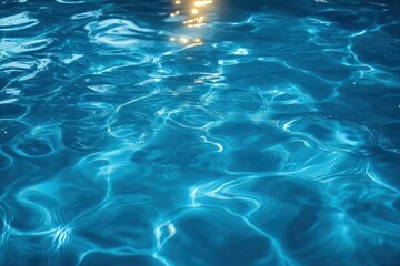 Obraz premium Close-up of clear blue water surface with gentle ripples and sunlight reflections creating shimmering patterns