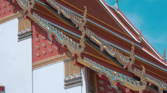 Red tiles with golden serpent-shape chofahs on the picturesque traditional Thai style roof of Wiharn Phra Mongkhon Bophit temple in Ayutthaya
