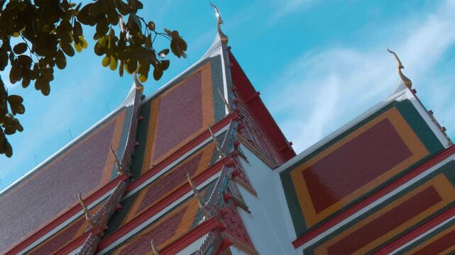 Red tiles with golden serpent-shape chofahs on the picturesque traditional Thai style roof of Wiharn Phra Mongkhon Bophit temple in Ayutthaya