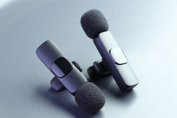 Lavalier microphones on light grey background, closeup