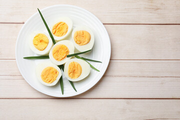 Boiled eggs and green onions on wooden table, top view. Space for text