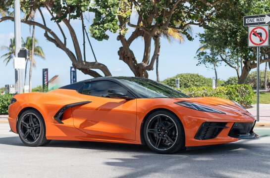 Miami, Florida, USA - December 20, 2024: Sport car of Chevrolet Corvette. Car of Chevy Corvette orange color outdoor. Chevrolet Corvette, side view. Chevrolet Corvette C8 Chevy supercar sportscar