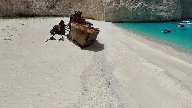 orbits around a ship that was shipwrecked on the coast of Greece with beautiful blue sea.
