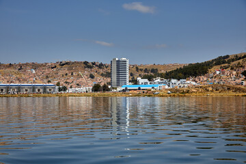 Fototapeta premium Sailing into the calm waters of Lake Titicaca’s channel stretch, with Puno city in the background.