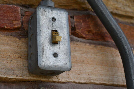Outdoor electrical switch mounted on top of public picnic structure.