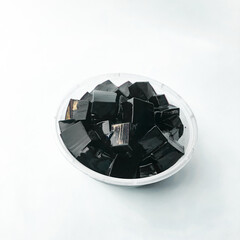 Black grass jelly slices placed in a bowl, grass jelly slices and drink placed in a glass cup and...