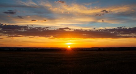 Obraz premium Photo of a Golden Sunset Over a Peaceful Field with Orange Sky