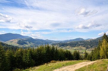 Wide angle view of a picturesque valley surrounded by forested mountains under a clear sky, showcasing natural beauty and tranquility. Carpathian Mountains, Ukraine