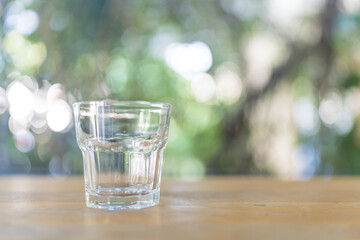 Empty glass of water on table against nature background