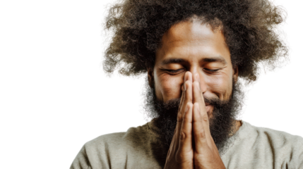 Man expressing gratitude with hands together in front of his face, isolated on a black background.