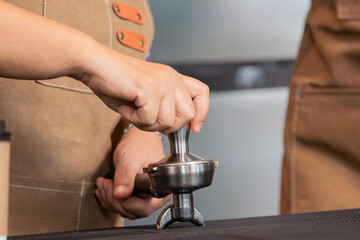 Young attractive barista teaching senior elderly retirement woman using POS matching cash register technology to receive customer orders, happy 60s aging society people working in small business cafe